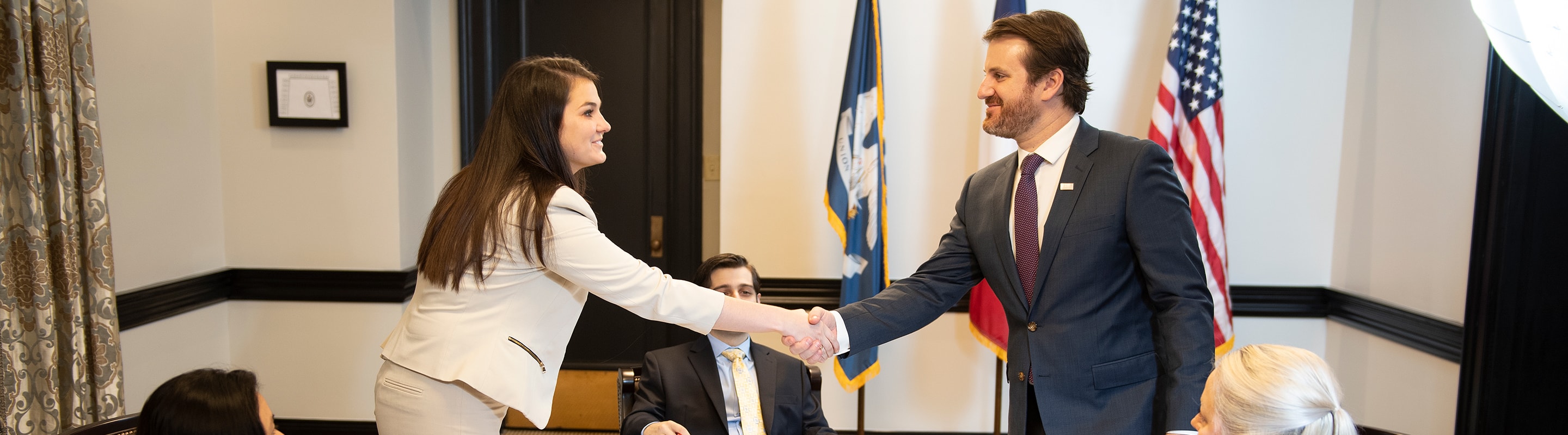 A Loyola Law student shakes hands with a client