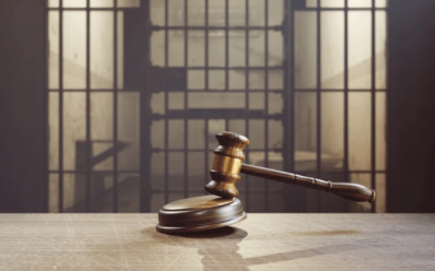 image of gavel in front of jail cell 