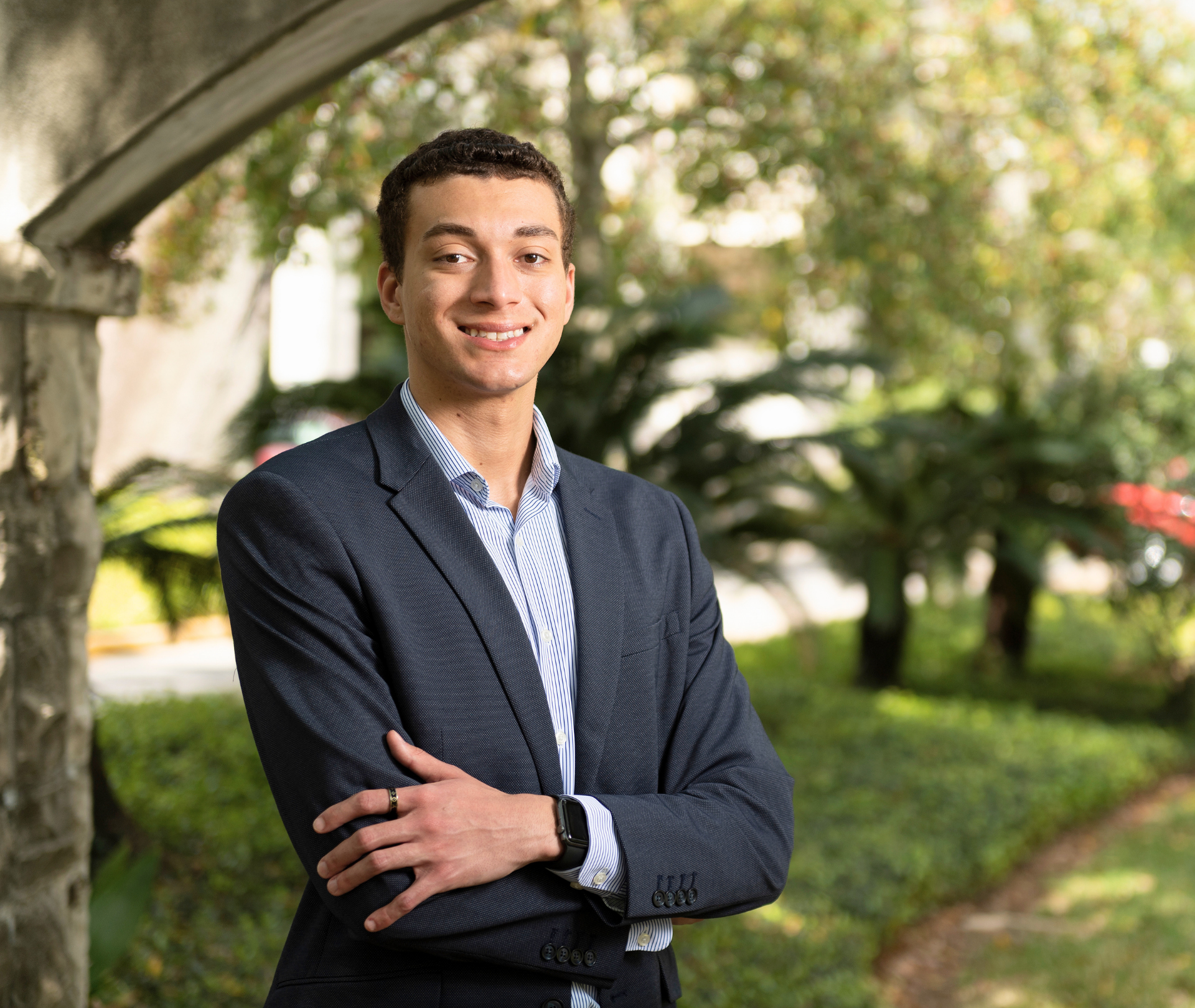 Student smiling with arms folded.